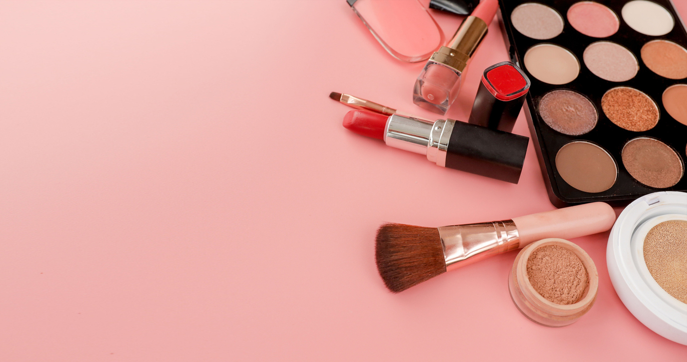 Cosmetics and beauty products arranged on a pink backdrop