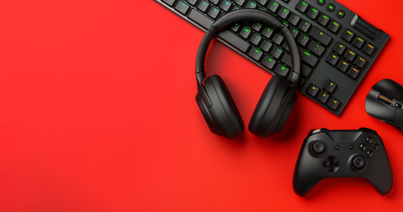Gaming and consumer electronics arranged on a red backdrop
