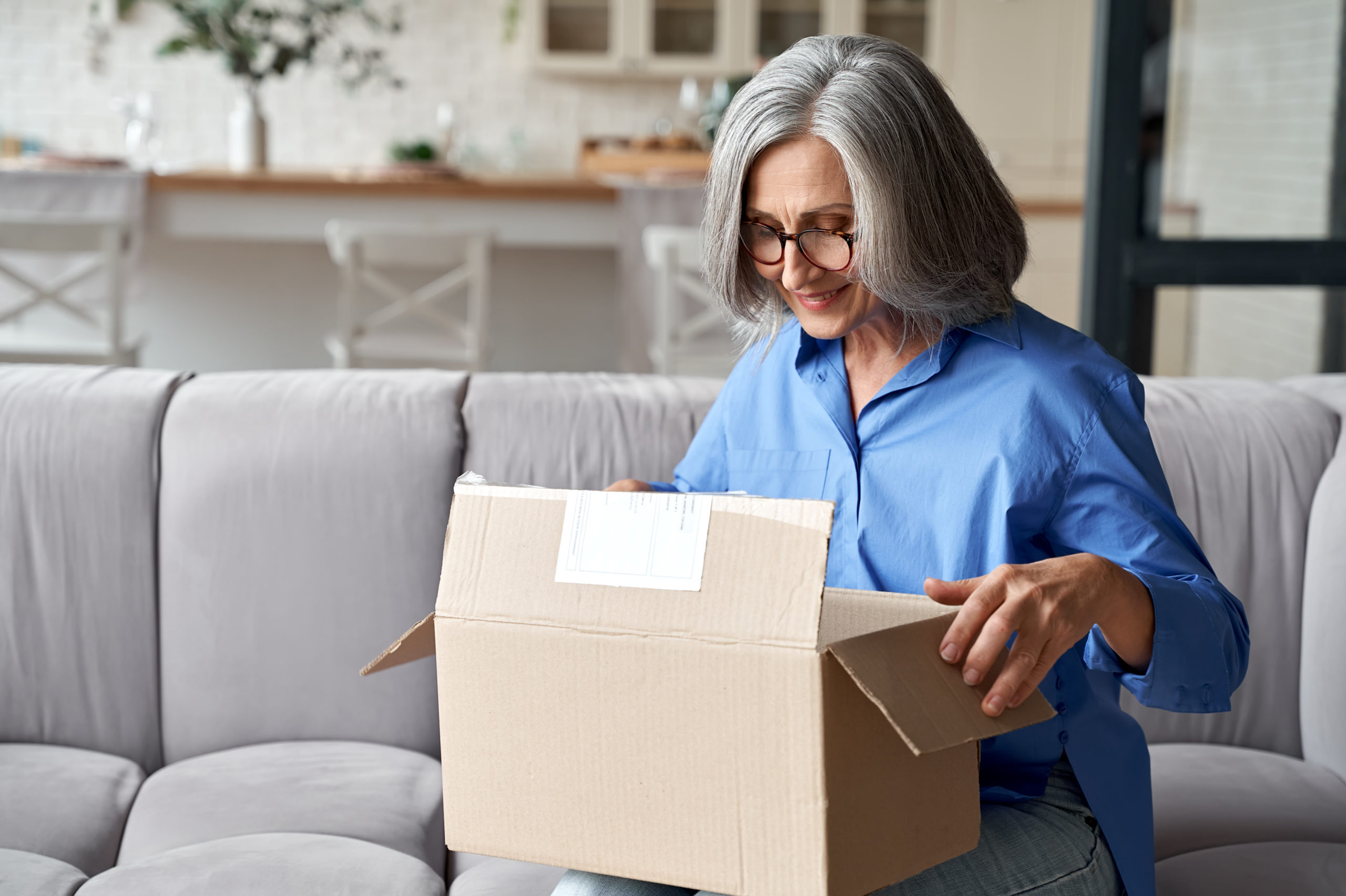Woman unpacking parcel from an online purchase from Amazon UAE