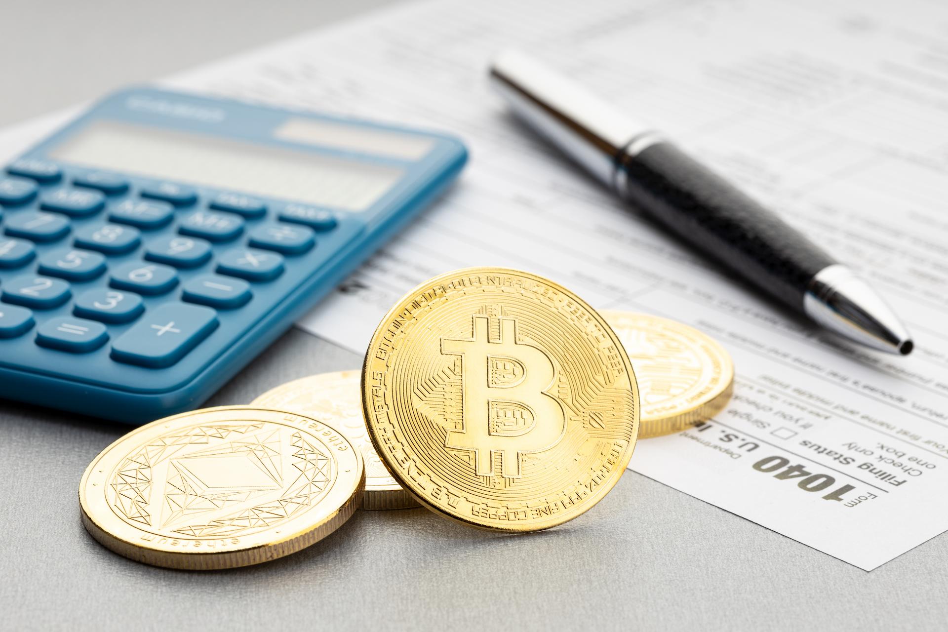 Some bitcoin next to a calculator when doing crypto tax