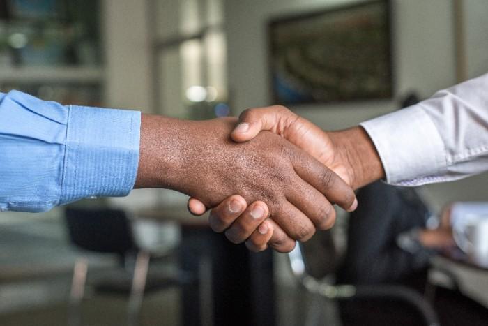 An image of two business men from Dubai and India shaking hands.