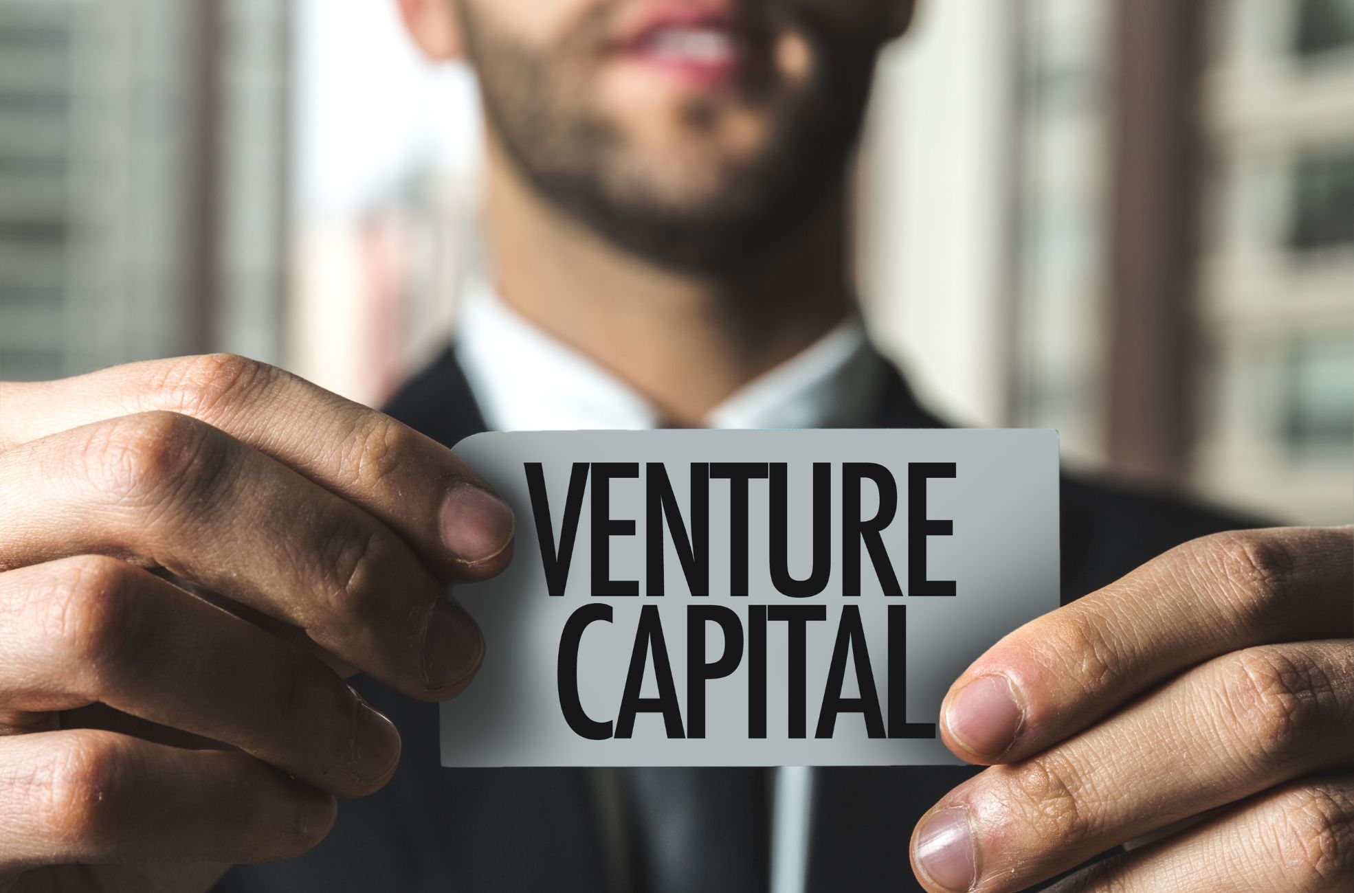 stock photo man holding sign saying venture capital