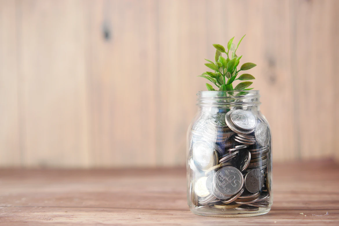 stock photo of a jar of money sprouting a plant 