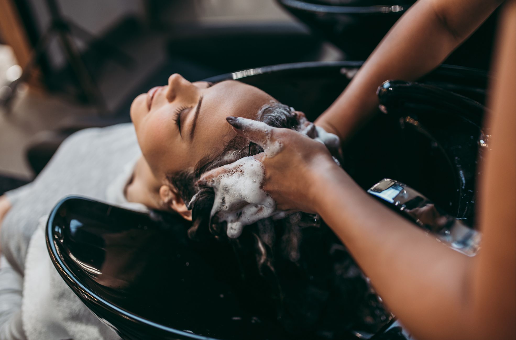 Hairdresser Washing Hair In Salon