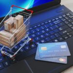 E-commerce Business Shown By Laptop, Credit Cards And Shopping Trolley