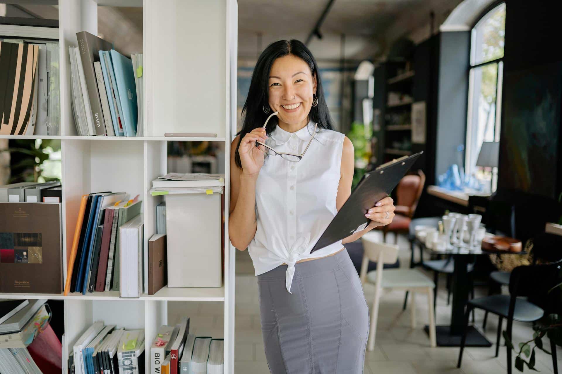 Business woman holding a clipboard in an office who has an event management license in Dubai