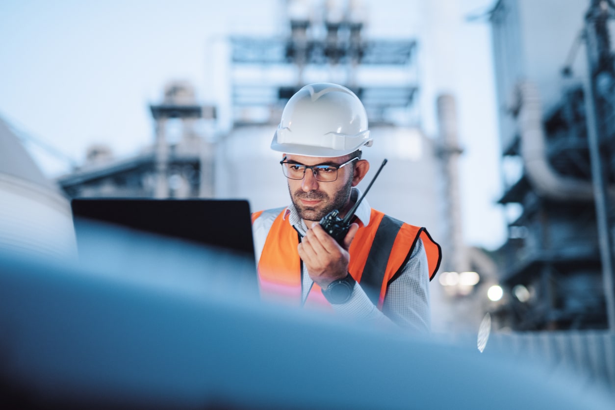 Engineer is reptorting a problem with a walkie talkie on the power station at a night shift